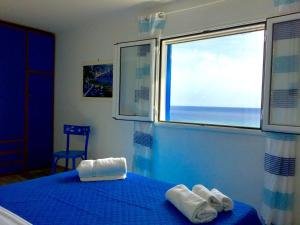 アルカモ・マリーナにあるLa Terrazza Sul Mareのベッドルーム1室(ブルーベッド1台、タオル付)
