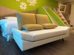 ein Sofa mit zwei Kissen darauf in einem Schlafzimmer in der Unterkunft Mesin-inn in Magong