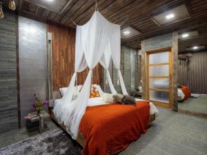 a bedroom with a bed with a canopy at Octopus Villas in Tejakula
