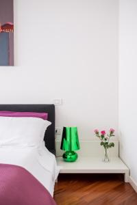a bed with a green lamp on a white table at The Jasmine Terrace Retreat in Bologna