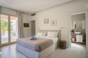 a bedroom with a large bed and a balcony at Tenuta DonnAnna Agriturismo&Glamping in Galatone