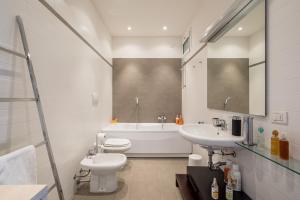 a bathroom with a toilet and a sink and a tub at The Jasmine Terrace Retreat in Bologna