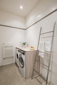 a laundry room with a washing machine in it at The Jasmine Terrace Retreat in Bologna