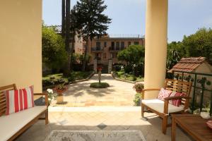 une terrasse avec 2 chaises et une cour avec un bâtiment dans l'établissement Villa Elide, à Vico Equense