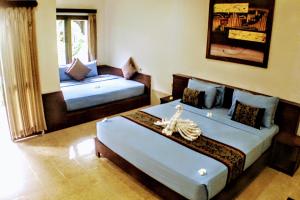 ein Schlafzimmer mit zwei Betten und einem Sofa darin in der Unterkunft D'Gilian Bungalow in Gili Trawangan