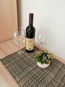 a bottle of wine and two wine glasses on a table at Studio Apartman Irena1 in Bijela