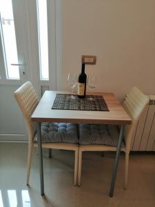 a table with two glasses and a bottle of wine at Studio Apartman Irena 2 in Bijela