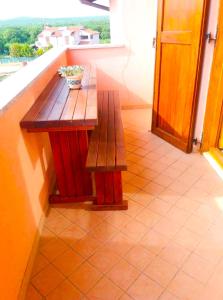 a wooden table and bench on a balcony at Mon Perin Castrum - Apartman Valentina in Bale