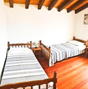 two beds in a room with wooden floors at Mon Perin Castrum - Apartman Valentina in Bale