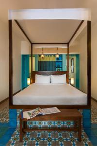 a bedroom with a large bed and a table at Villa Shanti - Heritage Hotel for Foodies in Puducherry