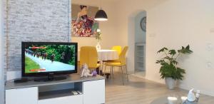 a living room with a flat screen tv on a cabinet at Apartment Ronaldo in Poreč