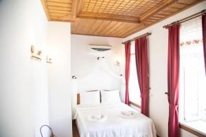 1 dormitorio con cama y ventana en Taşdelen Hotel, en Alacati
