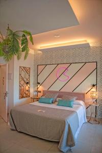 Amita Hotel Boutique "Only adults" في سوانسيس: غرفة نوم بسرير كبير عليها علامة وردية