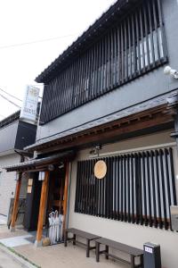 a building with a bench in front of it at Narita Sando Guesthouse in Narita