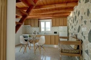a kitchen with a table and chairs in a room at Wisteria Apartments in Karterados