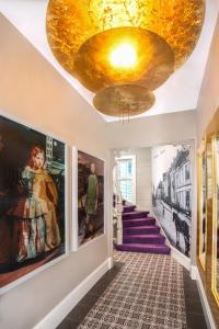 a hallway with a gold ceiling and paintings on the walls at 2 Døtre Apartments in Bergen
