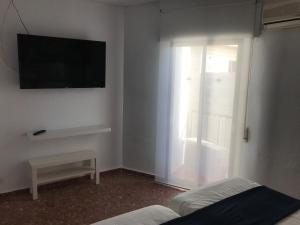 a room with a tv and a bed and a window at Hotel Playa San Cristóbal in Almuñécar +41 photos