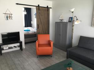 a living room with a couch and a chair and a bed at Amsterdam Beach Home 46 in Zandvoort