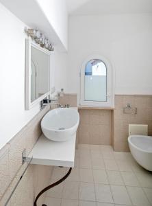 a white bathroom with two sinks and a mirror at Casa Gaia in Capri