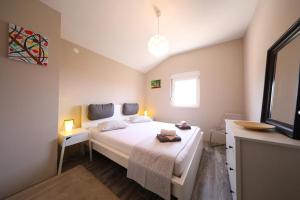 a bedroom with a large white bed and a window at Luxury Apartment RougeMarin in Pakoštane