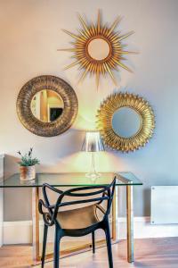 una mesa con una silla y tres espejos en la pared en 2 Døtre Apartments en Bergen