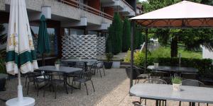 eine Gruppe von Tischen und Stühlen mit Sonnenschirmen im Innenhof in der Unterkunft Hotel-Restaurant Sonne in Talheim