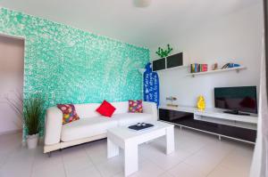 a living room with a couch and a tv at PoolViewZen in Corralejo
