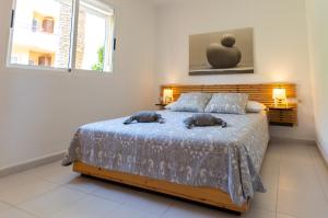 een slaapkamer met een bed met twee kussens erop bij PoolViewZen-CorralejoPlaya in Corralejo +22 foto's