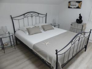 - une chambre avec un grand lit et des draps blancs dans l'établissement Bleuvelours, à Andernos-les-Bains