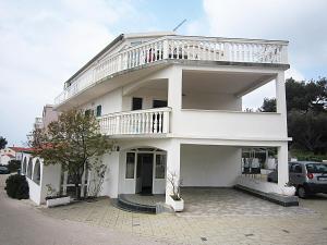 ein weißes Haus mit einem Balkon darauf in der Unterkunft Apartment house Berry in Primošten