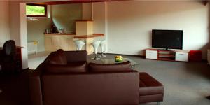 ein Wohnzimmer mit einem Sofa und einem TV in der Unterkunft Hotel-Restaurant Sonne in Talheim