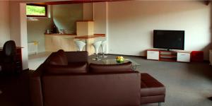 a living room with a couch and a tv at Hotel-Restaurant Sonne in Talheim