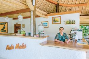 Un uomo seduto al bancone in un ristorante di Mule Malu Tropical Stay a Uluwatu