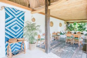 a dining room with a table and chairs and a wooden ceiling at Mule Malu Tropical Stay in Uluwatu