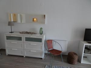 een wit dressoir en een stoel in een kamer bij Apartment La Isla Bonita in Jávea