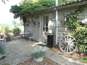 eine Terrasse auf der Rückseite eines Hauses mit einem Wagen in der Unterkunft Passe-Partout in Oedelem