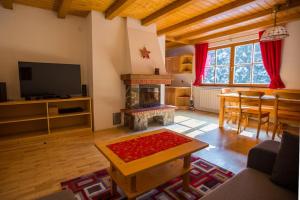 a living room with a fireplace and a dining room at Bolfenk lodge apartment in Pohorje