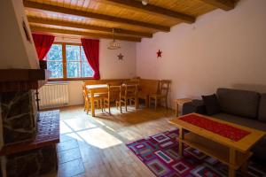 a living room with a couch and a table and chairs at Bolfenk lodge apartment in Pohorje