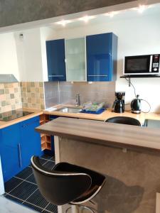 eine Küche mit blauen Schränken und einer Arbeitsplatte in der Unterkunft Le Mémorial apparthotel-GoodCaen in Caen
