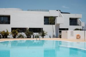 a large swimming pool in front of a white building at Sunset Apartment at Casilla de Costa in Villaverde
