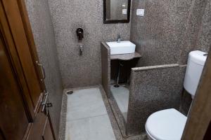 a small bathroom with a sink and a toilet at Tripli Hotels Prithvi Palace in Jaisalmer