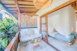a room with a porch with a chair and a table at Mule Malu Tropical Stay in Uluwatu