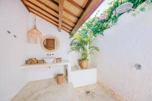 a bathroom with a sink and a potted plant at Mule Malu Tropical Stay in Uluwatu