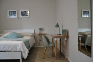 a bedroom with a bed and a desk and a chair at Le Fontanelle B&B in Sarno