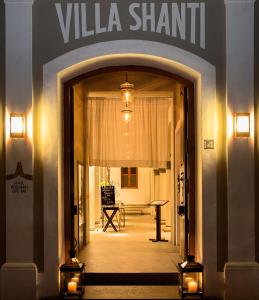 une entrée dans un bâtiment avec un panneau indiquant le partage de la villa dans l'établissement Villa Shanti - Heritage Hotel for Foodies, à Pondichéry