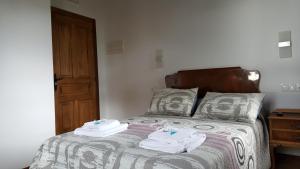 a bedroom with a bed with towels on it at La Posada del Druida in Foncebadón