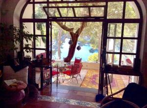 - un salon avec une grande fenêtre donnant sur un arbre dans l'établissement Villa Guya, à Capri 57 autres photos