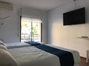
a bedroom with a bed and a television at Hotel Playa San Cristóbal in Almuñécar

