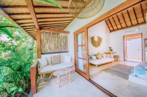 a living room with a couch and a chair at Mule Malu Tropical Stay in Uluwatu