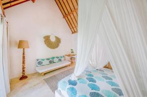 a bedroom with a bed with curtains and a couch at Mule Malu Tropical Stay in Uluwatu